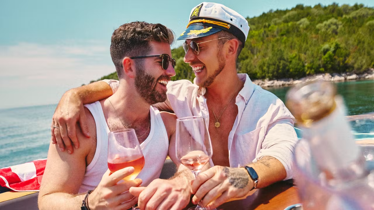 Two men toasting rosé on a boat
